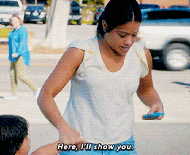 a woman says here i 'll show you while holding a child 's hand