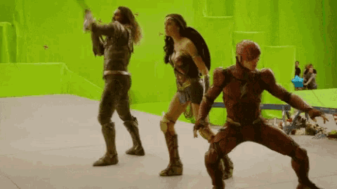 a woman in a wonder woman outfit is standing next to a man in a flash suit