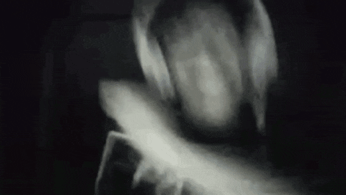 a black and white photo of a person in a hooded jacket .