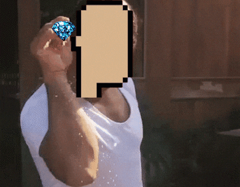 a man in a white tank top is holding a diamond in front of his face