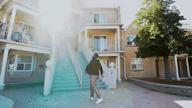 a person walking up a set of stairs in front of a building with a sign that says ' a '