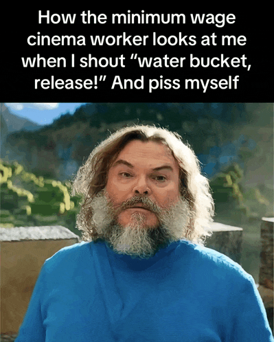 a man with a beard wearing a blue shirt says how the minimum wage cinema worker looks