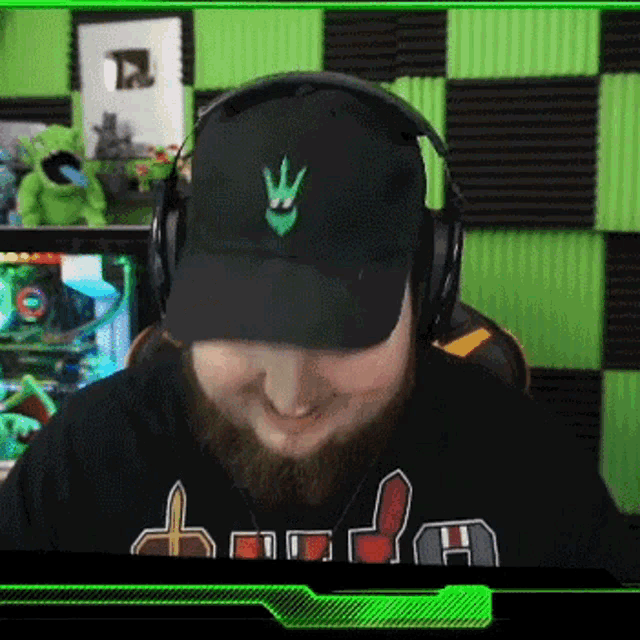 a man with a beard wearing headphones and a hat with a green crown on it