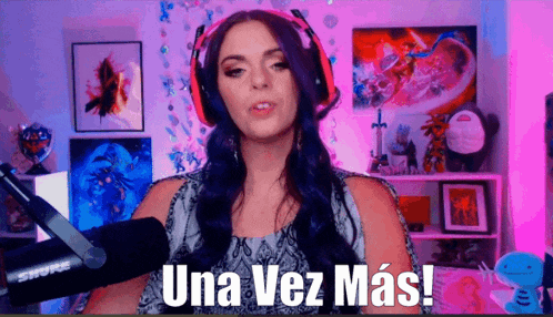 a woman wearing headphones stands in front of a microphone and says una vez más