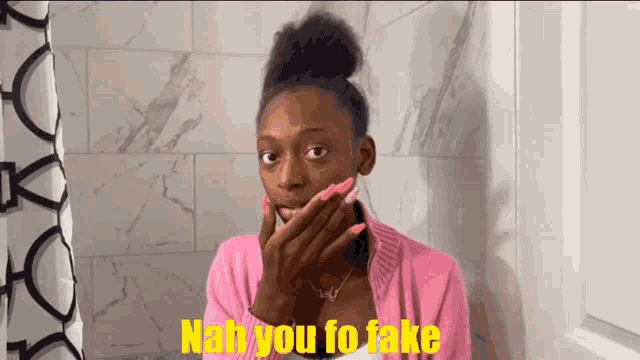 a woman in a pink sweater is covering her face with her hand and the words nah you fo fake are written in yellow