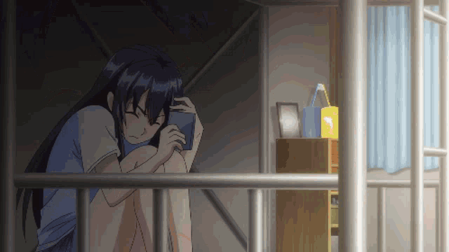 a girl is sitting under a bunk bed holding a phone