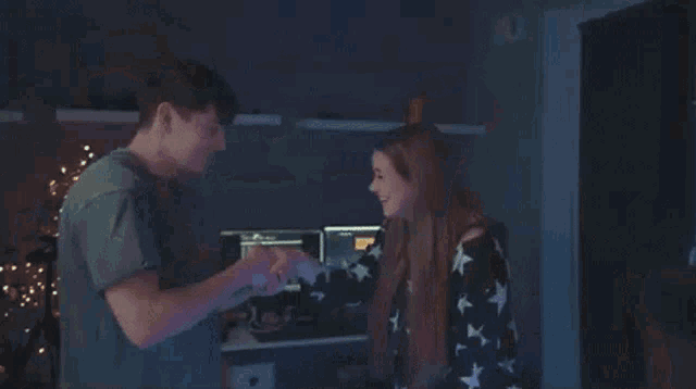 a man and a woman are shaking hands in front of a laptop computer .