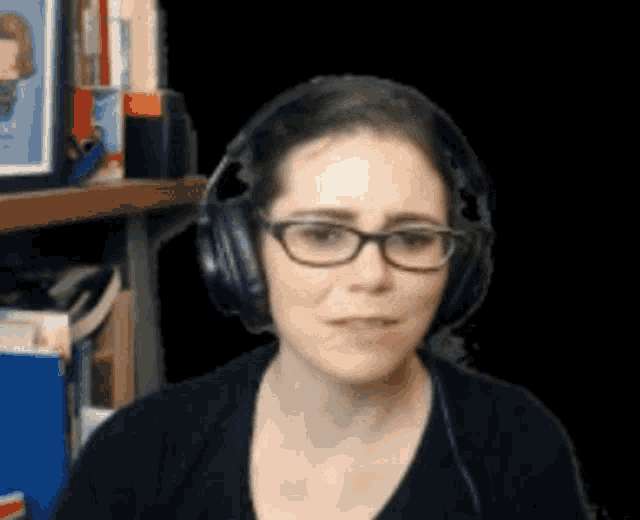 a woman wearing glasses and headphones is making a face