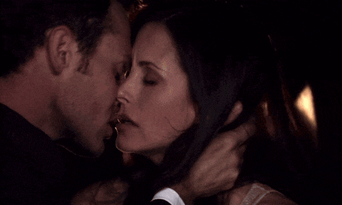 a man and woman are kissing in the dark