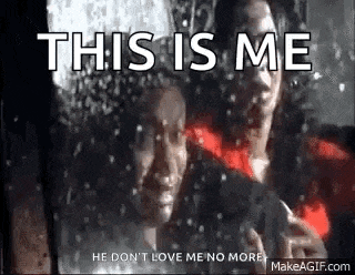 a man and a woman are standing next to each other in front of a window with snow falling .