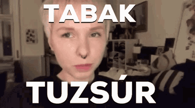 a woman with a nose ring looks at the camera with the words tabak tuzsur behind her