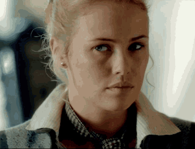 a close up of a woman 's face with a collared shirt