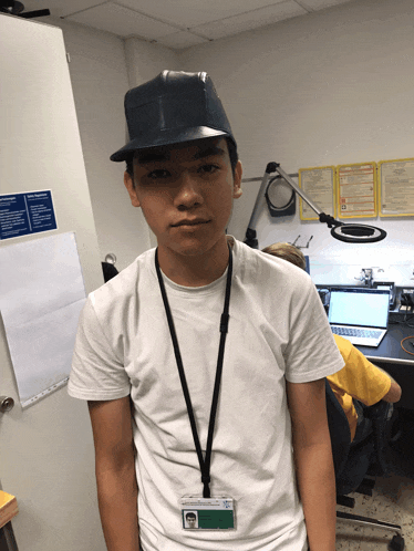 a young man wearing a hat and a lanyard with a name tag that says ' j. ' on it