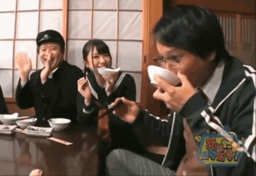 a group of people are sitting at a table eating food with a sign that says ' ao ' on it