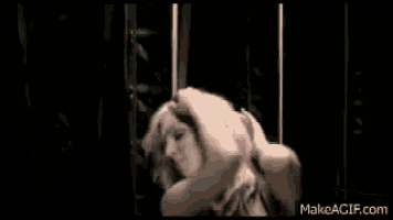 a naked woman is dancing in a dark room .