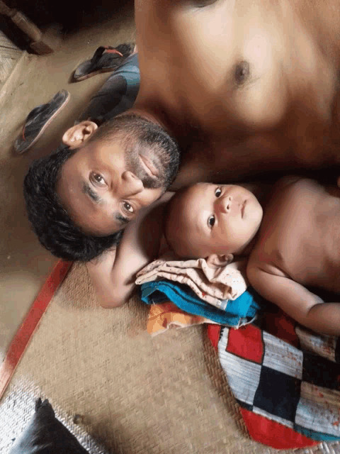 a man laying on a mat with a baby
