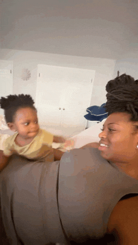 a woman is holding a baby in her arms while smiling .