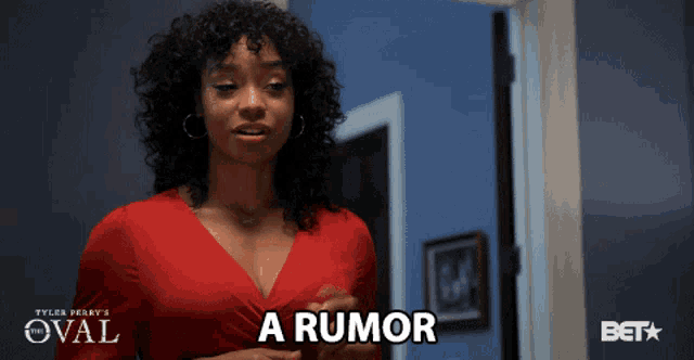 a woman in a red dress says a rumor in front of a blue wall