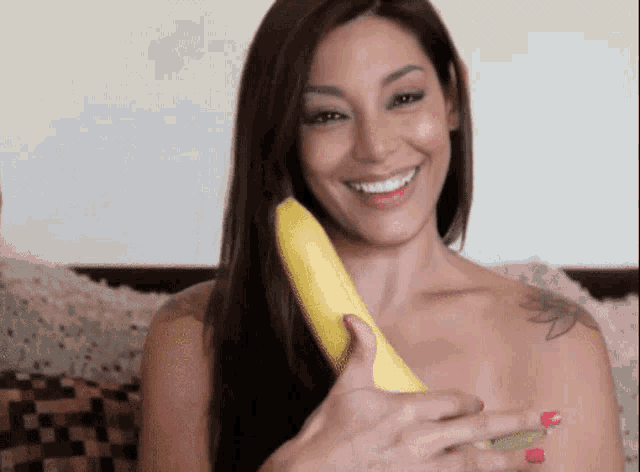 a woman with a tattoo on her arm is holding a banana
