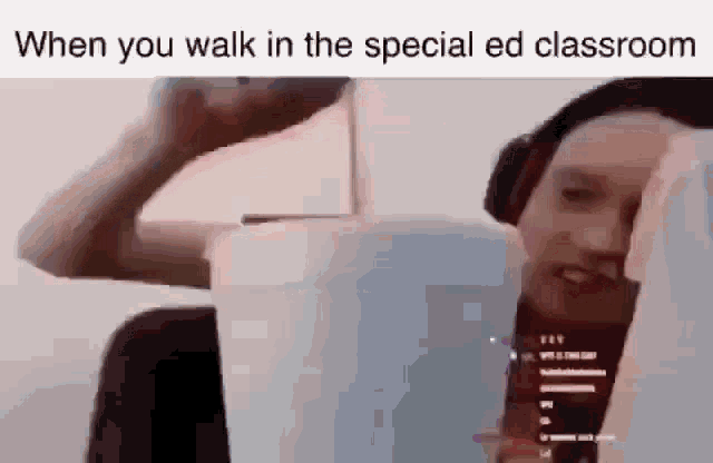 a man wearing headphones is walking in a special ed classroom with a bucket of water .