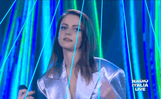a woman singing on a stage with the words radio italia live