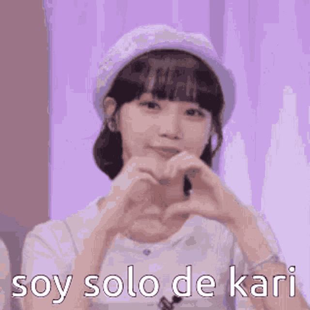 a woman is making a heart shape with her hands and the words `` soy solo de kari '' .