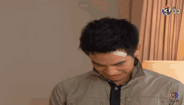 a man with a bandage on his forehead has the number 3 on the bottom right