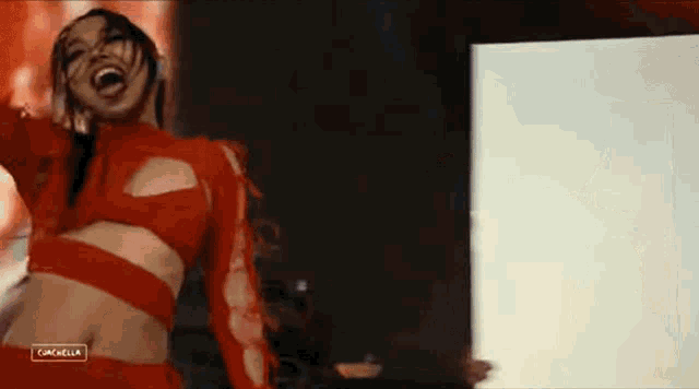 a woman in a red outfit is dancing on a stage .