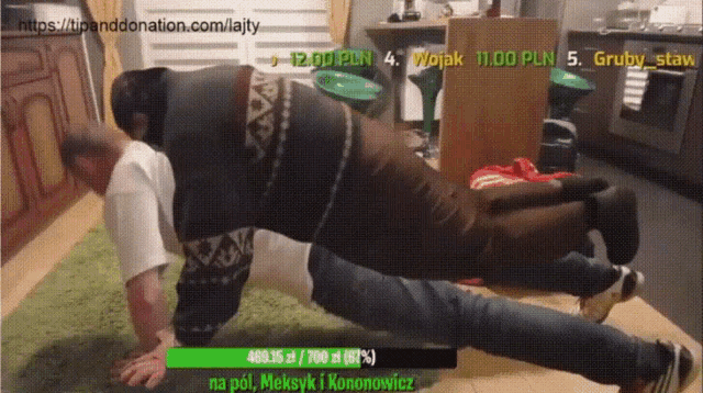 a man is doing push ups on another man 's back while a donation box is displayed on the screen