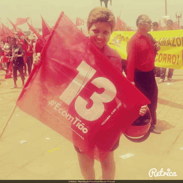 a woman holding a red flag with the number 13