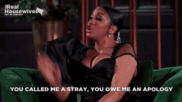 a woman in a black dress is sitting on a green couch and says " you called me a stray "