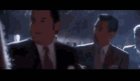 a group of people are standing in a dark room with their hands in the air .