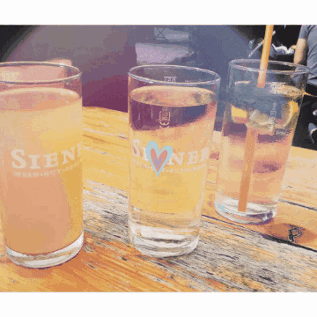 three glasses on a table with one that says siene