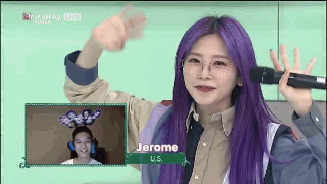 a woman with purple hair is holding a microphone in front of a sign that says jerome