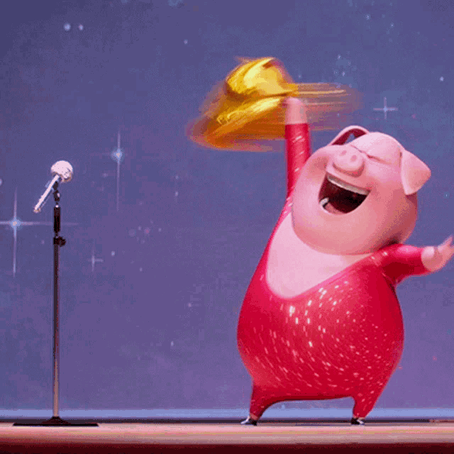 a cartoon pig in a red outfit is holding a yellow object in front of a microphone