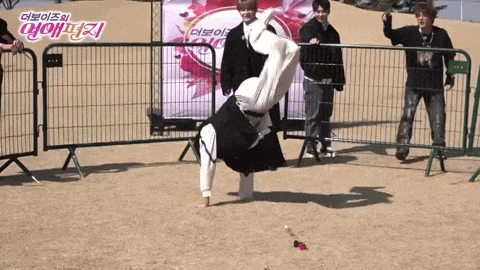 a man is doing a handstand in front of a fence with a sign that says ' a ' on it