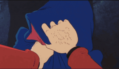 a person in a red shirt is holding a cartoon character in a blue blanket