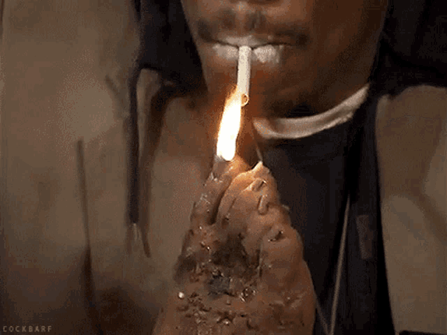 a man is lighting a cigarette with his foot