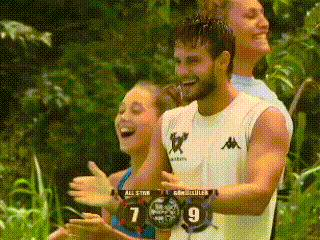 a group of people are clapping and laughing in the jungle while watching a game .