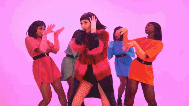 a woman in a fur coat is surrounded by other women in different colors