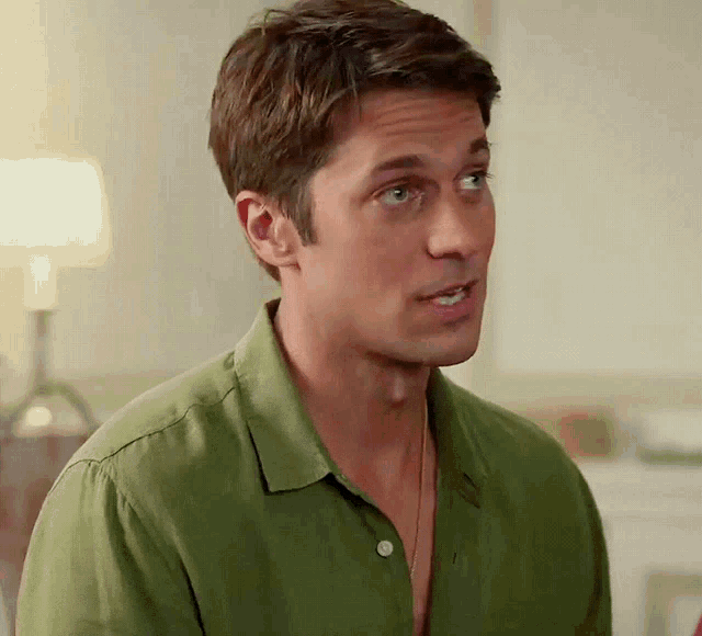 a man in a green shirt looks to his right