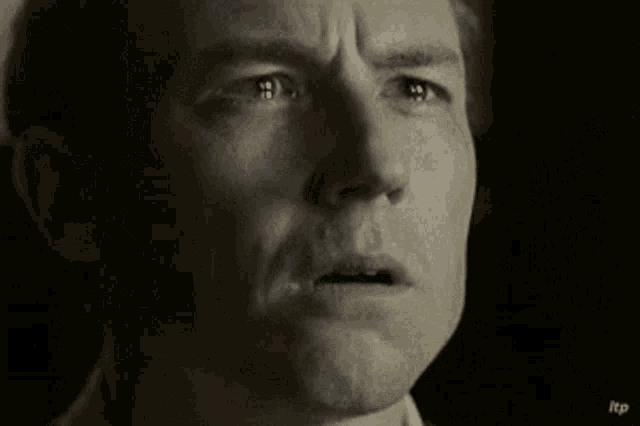 a close up of a man 's face with his mouth open and a serious look on his face .