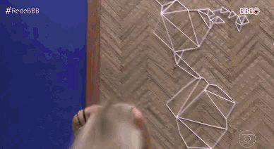 a woman is doing a handstand on a wooden floor in front of a blue background .