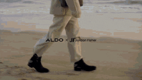a person walking on a beach with aldo x jordan fisher