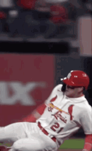 a baseball player in a cardinals uniform is sliding into base