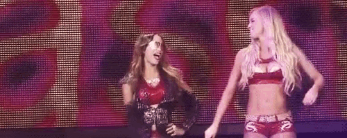 two women are standing next to each other on a stage .
