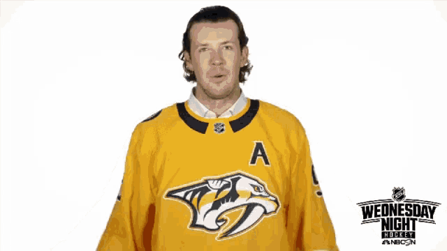 a man wearing a yellow jersey that says what on it