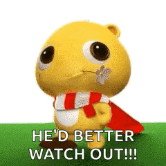 a stuffed animal wearing a scarf and a cape is standing in the grass .