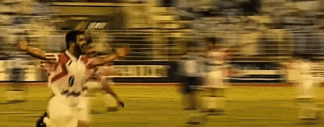 a blurry picture of a soccer game with a man wearing a number 9 jersey .