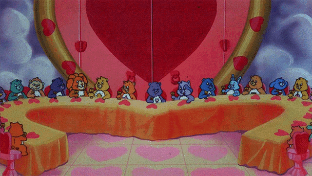a group of care bears are sitting at a long table